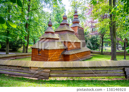 St. Nicholas church stands in Jiraskovy orchards, Hradec Kralove. This wooden structure dates back to the 16th century and was moved here in the 20th century. It is surrounded by trees. 138146928