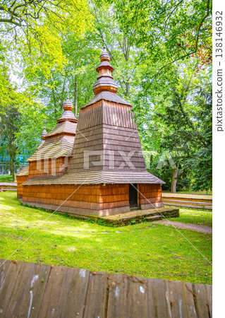Wooden church from the 16th century stands in Jiraskovy orchards in Hradec Kralove. This structure was moved to its current location in the 20th century. Trees surround the building. Wooden church from the 16th century stands in Jiraskovy orchards in Hradec Kralove. This structure was moved to its current location in the 20th century. Trees surround the building. 138146932