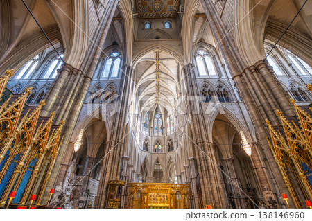 People visit Westminster Abbey in London to explore its historic architecture. Sunlight shines through stained glass windows, illuminating the high arches and detailed design inside. People visit Westminster Abbey in London to explore its historic architecture. Sunlight shines through stained glass windows, illuminating the high arches and detailed design inside. 138146960