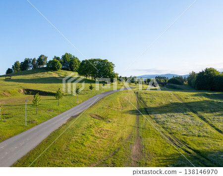 Cross-country skiing takes place at Vesec Sport Area in Liberec, Czechia. The area features well-maintained trails surrounded by green hills and trees under clear skies. Cross-country skiing takes place at Vesec Sport Area in Liberec, Czechia. The area features well-maintained trails surrounded by green hills and trees under clear skies. 138146970