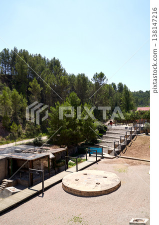 A scenic landscape featuring an open-air structure surrounded by trees and a bright blue pool, ideal for relaxation in nature. A scenic landscape featuring an open-air structure surrounded by trees and a bright blue pool, ideal for relaxation in nature. 138147216
