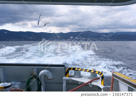 The view from the stern of the ferry departing Atami Port and heading towards Hatsushima Island. The view from the stern of the ferry departing Atami Port and heading towards Hatsushima Island. 138147371