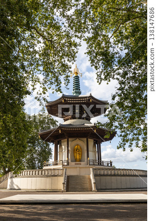 The London Peace Pagoda framed by green trees in Battersea Park 138147686