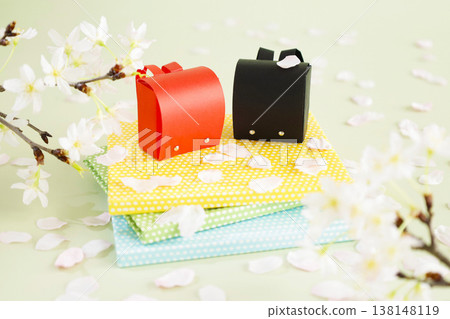 Cherry blossom petals and a school bag – a bright image of spring filled with hope. Cherry blossom petals and a school bag – a bright image of spring filled with hope. 138148119