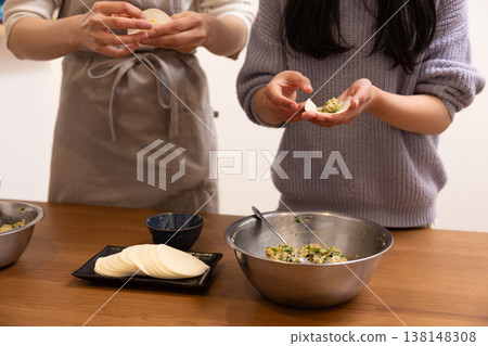 一位婦女和一位女孩正在包餃子皮 一位婦女和一位女孩正在包餃子皮 138148308