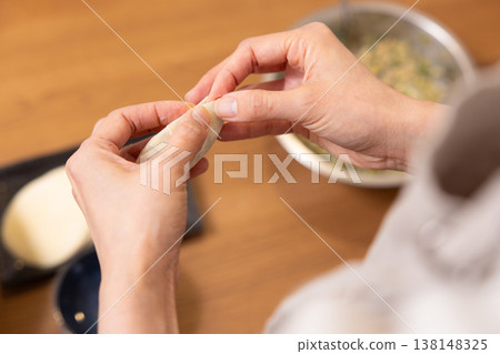 特寫鏡頭:雙手將餃子餡包進餃子皮裡。 特寫鏡頭:雙手將餃子餡包進餃子皮裡。 138148325