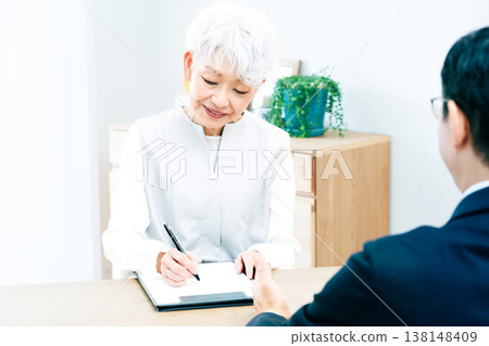 Senior woman listening to a salesperson's explanation Senior woman listening to a salesperson's explanation 138148409