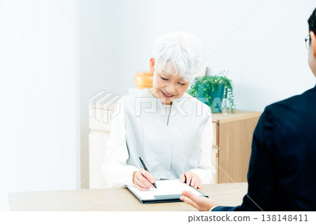 Senior woman listening to a salesperson's explanation Senior woman listening to a salesperson's explanation 138148411