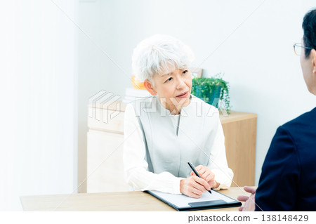 Senior woman listening to a salesperson's explanation Senior woman listening to a salesperson's explanation 138148429