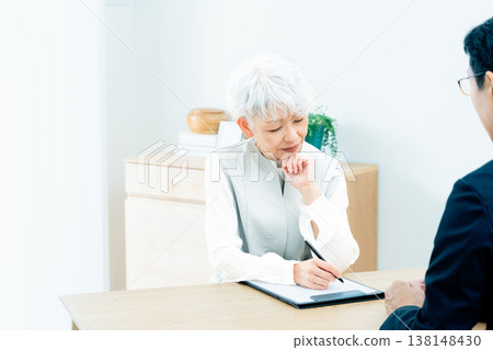 Senior woman listening to a salesperson's explanation 138148430