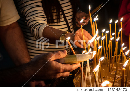 Christian pilgrims lighting candles in the Holy Sepulchre in Jerusalem. 138148470