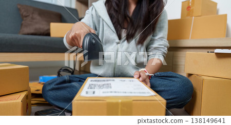 Woman scanning barcode on package for shipment Woman scanning barcode on package for shipment 138149641
