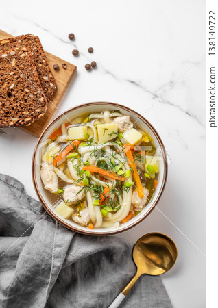 Chicken noodle soup with fresh dill in a bowl on a white marble background Chicken noodle soup with fresh dill in a bowl on a white marble background 138149722
