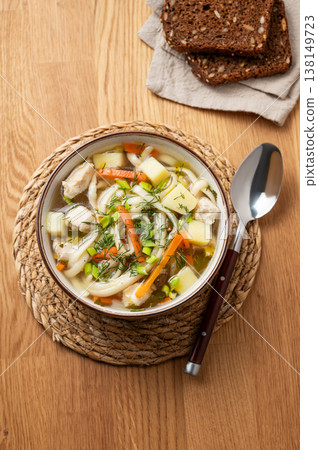 Chicken noodle soup with fresh dill in a bowl on a wooden background Chicken noodle soup with fresh dill in a bowl on a wooden background 138149723
