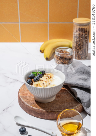 Greek yogurt with granola, blueberry and banana in a bowl on a marble table Greek yogurt with granola, blueberry and banana in a bowl on a marble table 138149760