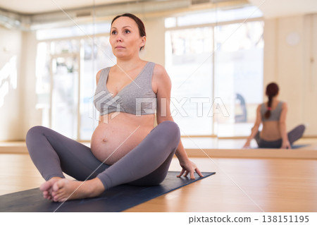 Pregnant woman is engaged in yoga. Butterfly Pose or Baddha Konasana Pregnant woman is engaged in yoga. Butterfly Pose or Baddha Konasana 138151195