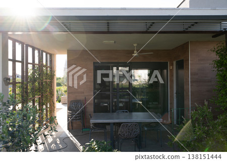 Modular house patio interior at sunset with smart robotic vacuum and outdoor dining area Modular house patio interior at sunset with smart robotic vacuum and outdoor dining area 138151444