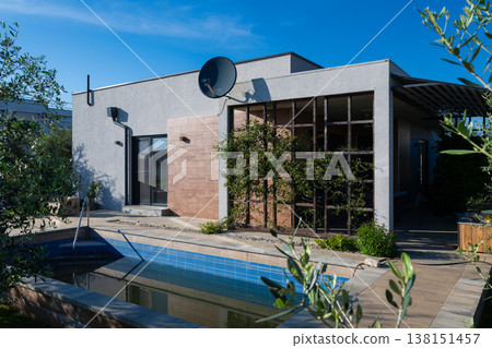 Modular modern house with pool, patio and smart home features at sunset with robot vacuum present Modular modern house with pool, patio and smart home features at sunset with robot vacuum present 138151457