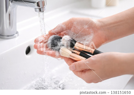 Washing makeup brushes under running water with soap hygiene and beauty care routine Washing makeup brushes under running water with soap hygiene and beauty care routine 138151650