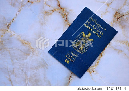Iraqi passport on table close up. Official identification document book for citizens of Iraq. Concept of travel and tourism Iraqi passport on table close up. Official identification document book for citizens of Iraq. Concept of travel and tourism 138152144