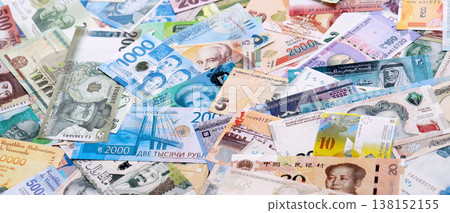 Different banknotes from many various currencies of the whole world. Big bunch of money bills on table close up Different banknotes from many various currencies of the whole world. Big bunch of money bills on table close up 138152155