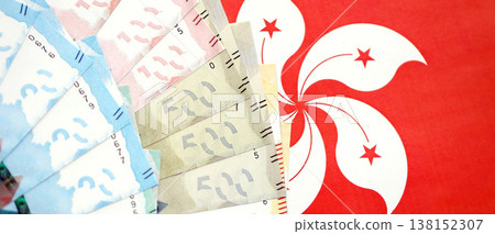 Big pile of Hong Kong dollars money bills banknotes on red flag. Lots of money of Chinese Hong Kong HKD currency cash. Economics and business in HongKong Big pile of Hong Kong dollars money bills banknotes on red flag. Lots of money of Chinese Hong Kong HKD currency cash. Economics and business in HongKong 138152307