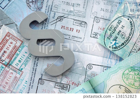 Paragraph symbol on passport pages full of colorful stamps after travel and tourism. Border control and lawsuit concept. Immigration and travel around the world 138152823