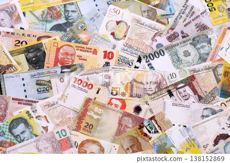 Various currencies money bills banknotes in yellow and orange color. Many cash bills from different countries in big pile close up. World economy and currency exchange concept Various currencies money bills banknotes in yellow and orange color. Many cash bills from different countries in big pile close up. World economy and currency exchange concept 138152869