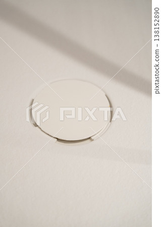 Bathtub drain showing a modern white circular design against a light background, emphasizing minimalism and hygiene within a sleek bathroom setting with soft shadows 138152890