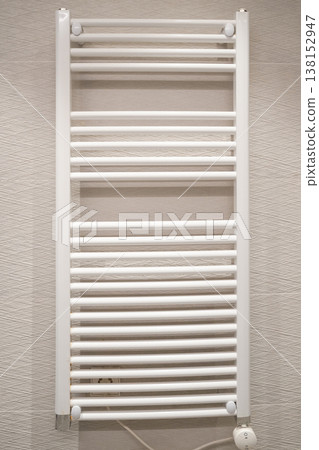 White towel warmer radiator creating warm comfort in a modern bathroom, offering a practical heating solution and stylish interior design element enhancing daily routines White towel warmer radiator creating warm comfort in a modern bathroom, offering a practical heating solution and stylish interior design element enhancing daily routines 138152947