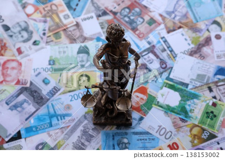 Themis figure against the background of pile of different currencies money bills. Concept of justice and corruption around the world 138153002