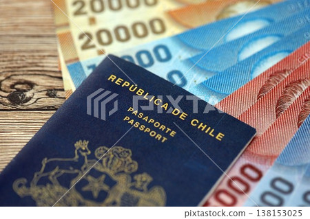 Chile Republic passport lies on wooden table with chilean pesos money bills close up. Chilean blue new passport book in details 138153025
