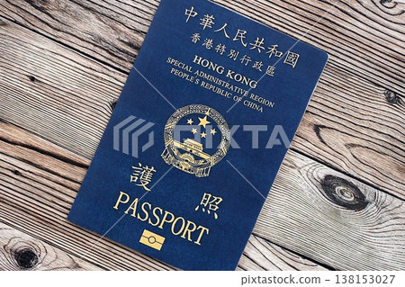 Hong Kong Special Administrative Region HKSAR Passport lies on wooden table background close up. Hong Kong blue new passport book in details 138153027
