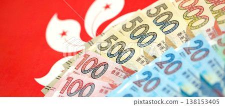 Big pile of Hong Kong dollars money bills banknotes on red flag. Lots of money of Chinese Hong Kong HKD currency cash. Economics and business in HongKong Big pile of Hong Kong dollars money bills banknotes on red flag. Lots of money of Chinese Hong Kong HKD currency cash. Economics and business in HongKong 138153405