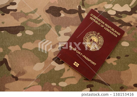 Uzbek passport on table close up. Official identification document book for citizens of Uzbekistan. Concept of travel and tourism in Uzbekistan Uzbek passport on table close up. Official identification document book for citizens of Uzbekistan. Concept of travel and tourism in Uzbekistan 138153416