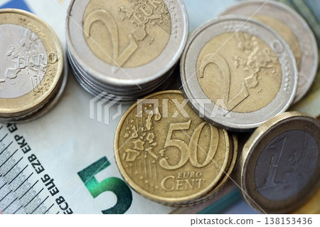 Eurozone euro money bills and cent coins pile on table. Eurozone coins on banknotes of EUR currency close up. Concept of business, taxes and banking in Eurozone Eurozone euro money bills and cent coins pile on table. Eurozone coins on banknotes of EUR currency close up. Concept of business, taxes and banking in Eurozone 138153436
