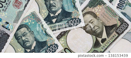Japanese yen money bills pile on table. Japan banknotes of JPY currency close up. Concept of business, economy and banking in Japan 138153439