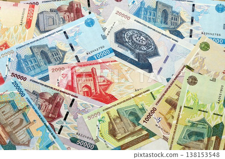 Uzbek som money bills pile on table. Uzbekistan banknotes of UZN currency close up. Concept of business, economy and banking in Uzbekistan 138153548