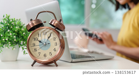 Time management and financial planning concept with clock and laptop 138153617