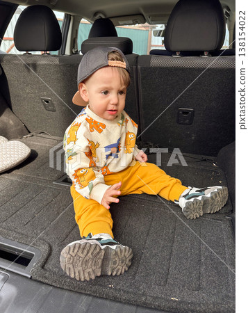 Toddler sitting in open car trunk during family road trip Toddler sitting in open car trunk during family road trip 138154022