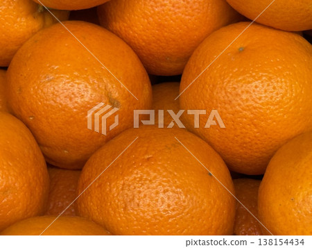 Oranges stacked together forming a textured background of fresh and vibrant citrus fruits 138154434