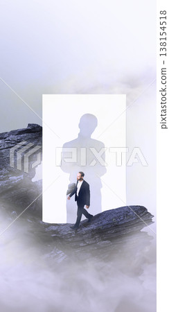 Businessman walking through human silhouette cutout on rocky cliff in fog. 138154518
