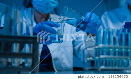 Scientist mixing chemical liquids in the chemistry lab. Scientist mixing chemical liquids in the chemistry lab. 138154670
