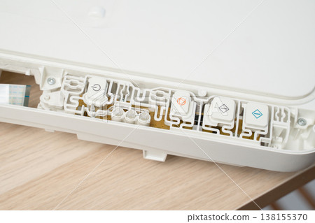 Closeup view of a white electronic control panel showing membrane buttons, printed circuit board traces and mechanical housing, Device repair, electronics maintenance, technology and DIY guides. Closeup view of a white electronic control panel showing membrane buttons, printed circuit board traces and mechanical housing, Device repair, electronics maintenance, technology and DIY guides. 138155370
