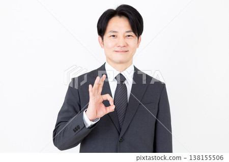 一位中年商人擺出了一個圓圈的姿勢。 一位中年商人擺出了一個圓圈的姿勢。 138155506