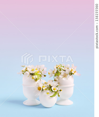 White Easter eggs with spring pear and strawberry flowers on a pink blue gradient background. Happy Easter concept. Greeting card. 138155560
