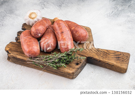 Uncooked pork sausages made from minced meat in natural casing served on cutting board 138156032
