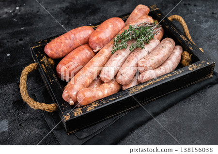 Mix of raw pork sausages in wooden tray with herbs Mix of raw pork sausages in wooden tray with herbs 138156038