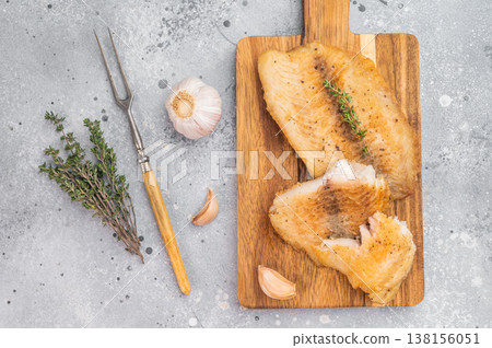 Golden fried tilapia fish fillets on wooden tray over gray background, fresh white fish seafood meal. Golden fried tilapia fish fillets on wooden tray over gray background, fresh white fish seafood meal. 138156051