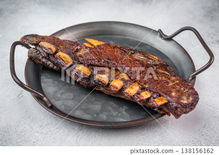 BBQ Grilled lamb breast ribs with crispy crust in cast iron skillet on dark stone background barbecue meat with copy space BBQ Grilled lamb breast ribs with crispy crust in cast iron skillet on dark stone background barbecue meat with copy space 138156162